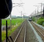 Serie 701 des Bezirks Morioka - im Schatten des Shinkansen begegnet ein Zug Serie 701 bei Yahaba, 5.Juli 2010.