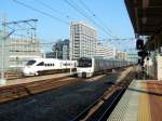 Serie 811: Einfahrt eines Zuges mit 2 4-Wageneinheiten, KUHA 810-110 an der Spitze, in den Hauptbahnhof Hakata in der Grossstadt Fukuoka. Daneben ein Intercity-Zug Serie 885. 27.November 2010. KAGOSHIMA HAUPTLINIE (NORD)