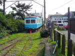 Triebwagen 701 und 702: 702 hat im Januar 2010 seine letzte Fahrt absolviert und steht, zusammen mit einem verrosteten Aussichtswagen, auf den letzten Metern Gleise der Bahn im Fischerdorf Tokawa,