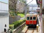 Hanshin Konzern, Mukogawa-Linie: Diese kurze Linie zweigt unterwegs ab und führt 1,7 km in eine mit Wohnsilos dicht überbaute Siedlung im Industriegebiet nahe am Meer. In Mukogawa wartet Zug 7864/7964 (Serie 7861; 3 Zweiwagenzüge von 1966/68, 2020 durch Züge der Serie 5500 ersetzt), 22.März 2014. 