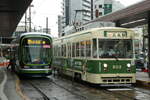 Rechts das Foto: Serie 800 Nr.806; Links das Foto: route 6 von Hiroshima Bahnhof nach Eba, mit die Serie 1000  GREEN MOVER LEX  Nr.1004 der Hiroshima Electric Railway (Straßenbahn); am 12.08.2021, Haltestelle Hiroshima Bahnhof.