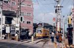 Einst und jetzt: Nishigahara Yonchme im alten nrdlichen Stadtteil von Tokyo. Wagen 7020 legt sich in die Kurve, um den Berg hinabzufahren. Noch ist der gelbe Anstrich blich. 7.Mrz 1978. 