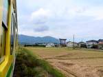 Serie 115 - die Bahn am heiligen Berg Yahikosan: Der Zug nähert sich dem Yahikosan. Dass man von hier an den Gottheiten geweihtes Land betritt ist am hoch aufragenden Tor zu erkennen, von dem ab der eigentliche Schreinzugang erfolgt. In Zug 115-501, bei Yahagi. 17.Oktober 2011. 