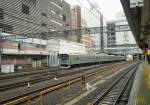 Serie 205: Die Züge der Saikyô-Linie (vom Nordwesten von Tokyo durch die Stadt und unter die Tokyo-Bucht hindurch) tragen ein grünes Band. Gerade verlässt ein Zug mit zwei  Stehwagen  (an 2. und 3. Stelle, 6-türig, einfache Sitzbänke klappen erst nach Ende der Stosszeit herunter) die riesige Station Shinjuku in Tokyo. Zug mit Steuerwagen KUHA 204-94, 27.Februar 2010. (nach Norden sind Steuerwagen KUHA 204, nach Süden KUHA 205 eingereiht)  SAIKYÔ-LINIE