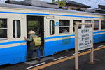Lokalverkehr auf Shikoku - der Nordosten: An japanischen Stationen finden sich stets Hinweistafeln zu den örtlichen Sehenswürdigkeiten, hier zum Tatsue-Tempel, der 19.Station auf der Pilgerroute um die Insel Shikoku mit seinen 88 Pilgerstationen herum. Gerade besteigt ein Pilger den Triebwagen KIHA 47 145. 3.April 2015.   