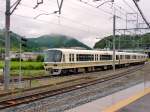 Serie 221, gebaut 1989-1991 für den Nahverkehr auf den Hauptachsen um die Städte Kobe-Osaka-Kyoto. Heute sind viele dieser Züge in ländliche Gebiete verdrängt, wie hier im Bild in Sonobe, tief in den vom Monsunregen nassen Bergen im Hinterland von Kyoto. Endwagen KUMOHA 221-76. 17.Juni 2011. 
