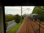 Der Hankyû-Konzern - Die Züge der 1980er Jahre: Serie 7300 aus den Jahren 1982-1989. Der modernisierte 8-Wagenzug 7320 (Endwagen 7400) erreicht am Rande von Osaka bald die Endstation Kita Senri. Diese Züge fahren auch auf die U-Bahn Sakaisuji-Linie ein. 1435 mm Spur, Gleichstrom 1500 V. Einige Wagen sind in Serie 8300 eingereiht. Es gibt 2- und 8-Wagenzüge. 28.September 2009. (Aufnahme durch die verglaste Führerstandrückwand eines Gegenzugs)