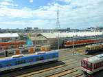 Auf der Fahrt im Zug des Hanshin-Konzern kommt man auch am Betriebswerk Amagasaki vorbei, in dem Hanshin Expresszüge (beige/orange und silbrig mit orangen Türen), Hanshin Lokalzüge