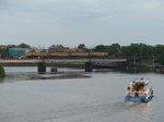 Verkehr auf dem Wasser und auf dem Lande: Nach einem heftigen Regenschauer traut sich die Abendsonne noch nicht so recht hinaus. Ein Zug der Baureihe ER2 überquert mit markant dröhnendem Gleichstrommotor die Daugava. 6.8.2016, Riga