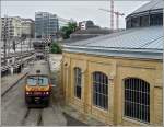 Der Triebzug 2004 fhrt im Bahnhof von Luxemburg an den beiden Ringschuppen (rotondes) vorbei zum Abstellplatz. Diese Rotunden sollten der Spitzhacke zum Opfer fallen, dann wurde zum Glck beschlossen sie zu restaurieren. Im Vordergrund sieht man das Resultat dieser Instandsetzung, whrend der hintere Ringschuppen noch darauf wartet. Das Bild wurde am 06.06.09 von der Fugngerbrcke (passerelle) aus aufgenommen. (Jeanny) 