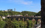 Regionalzug auf dem Viadukt vor den Hochhäusern in Luxemburg.