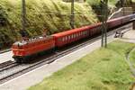 Im Bahnhof Hochgrieß am Scheitelpunkt des Olfapass wartet am 10.8.1987 die fabriksneue 1044 123 mit dem Zug der Züge auf die Weiterfahrt nachdem das Nachschiebetriebfahrzeug abgekuppelt