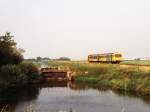 DH II 3207 mit Regionalzug 8621 Leeuwarden-Groningen neben das alte Schleusenwerk in die Tytsjerksterfeart bei Leeuwarden am 06-08-1990.