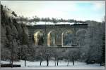 Im Gegenlicht fhrt Dampflok 52.4984  Eberhard  ber das 46m hohe Kalte Rinne Viadukt am Semmering.