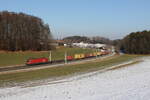 1016 021 mit einem Containerzug aus Salzburg kommend am 19. Februar 2025 bei Axdorf im Chiemgau.