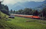 Zwischen Schladming und Stein an der Enns durchfährt eine 1044 mit einem Schnellzug im September 1986 das Ennstal