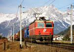 09. März 2002, Vor der Kulisse des Steinernen Meers befördert Lok 1044 046-9 der ÖBB bei Zell am See einen Güterzug nach Süden. 