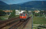 1044 007-4 überquert Ende der 1990er Jahre mit einem Regionalzug Richtung Arnoldstein die alte Draubrücke in Villach.