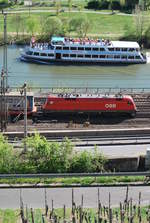 ÖBB-Taurus-Lok mit Containerzug kreuzt ein Schiff den Main entlang. 19. April 2019