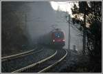 Aus dem Morgennebel taucht am 25.11.2006 1116 210 mit ihrem R 2353 von Bernhardsthal nach Payerbach-Reichenau auf. Die Aufnahme entstand kurz nach der Haltestelle Schlglmhl.