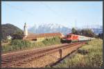 Die 1116 135 bringt im Sommer 2005 den EuroCity 84 Michelangelo vom Brenner in die Bayerische Landeshauptstadt, und passiert bei Oberaudorf das Kloster Raisach. Im Hintergrund erhebt sich das Kaisergebirge.