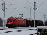 1116 089-4 durchfährt bei Schneetreiben mit einem Güterzug den Bhf. Redl-Zipf in Richtung Salzburg; 160301