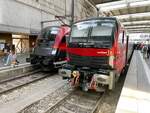 Railjet 1 (links) mit einer Taurus ÖBB BR 1116 neben einem Railjet  Steuerwagen der 2.Generation (rechts) in München Hbf auf den Gleisen 11 & 12 am Vormittag des  13.04.2024