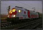 Im Morgennebel steht die Rot Kreuz Taurus 1116 264 mit einem Gterzug im Bahnhof Knittelfeld.