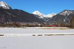 Die 1144 238 bespannte am 19.1.2025 einen Leerganzzug von Linz Stahlwerke nach Jesenice hier kurz vor dem Bahnhof Selzthal im noch recht breiten Ennstal vor einem herrlichen Bergpanorama.