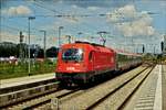 ÖBB Lok 1216 032 fährt mit ihrem Zug und den roten Lichtern voraus in den Bahnhof München Ost ein.