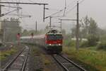 Im strömenden Regen bringt am 3.6.2024 die 1144 095 den EC151  Emona  von Wien Hbf nach Spielfeld-Straß hier bei der Durchfahrt im Bahnhof Wildon.