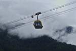 Eine Gondel der Penkenbahn vor den mit Nebel behangenen Bergen, aufgenommen in der Nähe der Talstation in Mayrhofen  19.08.2024