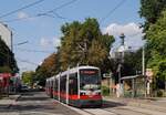 Tw.647 verläßt als Linie D die Haltestelle Augasse, rechts im Hintergrund erkennt man den Turm der Müllverbrennungsanlage Spittelau. (16.08.2024)