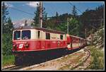 1099 008 ereicht am 3.06.2000 mit R6808 den Bahnhof Erlaufklause. Über dem Führerstand der Lok ist der Ötscher zu erkennen.