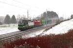 Im dichten Schneefall fahren am 22.11.2024 die 193 239 und die 1016 017 mit einem Containerganzzug von St.Michael kommend nach Selzthal hier kurz vor dem Bahnhof Trieben.