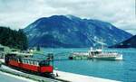 Achenseebahn__Der 2-Wagenzug drückt zurück zum Umsetzen für die Talfahrt. Am Schiffsanleger das Motorschiff 'Stadt Innsbruck'(ursprünglich 'Stella Maris') von 1911, seit 1994 außer Betrieb.__08-08-1973