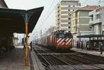 Mit einem langen Personenzug trifft eine Lok der Reihe 2500 am 28.04.1984 im Bahnhof Espinho südlich von Porto ein.