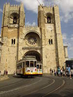 Begegnung der Strassenbahnwagen Nr. 575 und 554 mit der gelb-weisse Standartlackierung unterwegs als Linie 28 nach Prazeres und als Linie 28 nach Carreira am 23. April 2017 vor der  Catedral Sé Patriarcal Sé de Lisboa  in Lissabon.