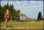 Der Dieseltriebzug der Baureihe Littera Y2 (Krösatågen Nr. 1384) hat am 18.08.2024 den Bahnhof Vimmerby verlassen und fährt dem nächsten Halt Hultsfred entgegen. Die zulässige Streckenhöchstgeschwindigkeit beträgt hier an diesem ungesicherten Bahnübergang 120 km/h. Ziel des Zuges ist die Stadt Kalmar an der Ostseeküste. Die  Gumminasen  genannten Triebzüge verkehren auf der Strecke Linköping - Kalmar als  Kustpilen  ( Küstenpfeil ).