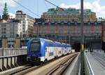 Doppelstock-Vorortstriebzug in der Nähe des Bahnhofs Stockholm C fährt nächstens unter den Häusern hindurch. Stockholm, 5.8.2024