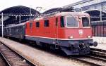 Am 27.3.1990 steht die rote Re 4/4 Nr. 11373 vor einem aus grnen Schnellzug
wagen gebildeten Personenzug abfahrbereit im Bahnhof Luzern.