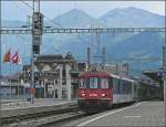 Hier kommt noch ein  richtiger  (wenn auch bunt zusammen gemixter) Zug der BLS vom Ltschberg und fhrt vor der schnen Bergkulisse in den Bahnhof von Spiez ein.