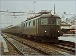 Die SBB Re 4/4 I 10039 wartet mit einem ungewöhnlichen und ungewöhnlich langen Regionalzug 3933 nach Basel SBB in Delémont auf die Abfahrt.