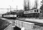 YSC/SBB: Zufällige Begegnung auf dem parallel verlaufenden Streckenabschnitt bei Yverdon les Bains zwischen dem YSC Be 4/4 4 und der SBB Re 4/4 I 10034 im April 1987.