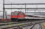 Re 4/4 II 11111 durchfährt bei regnerischem Wetter den Bahnhof Muttenz. Die Aufnahme stammt vom 01.05.2017.