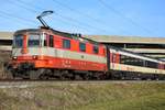 Re 4/4 II 11109 in Swiss-Express-Farben zieht am 23.02.2019 einen Interregio von Sissach kommend in Richtung Basel SBB.