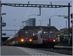 Die SBB Re4/4 11135 mit ihrem IR 1556 Neuchâtel (ab 7:22) - Lausanne (an 8:45) kurz vor der Abfahrt in Neuchâtel, daneben ein SBB RBDe 560  Domino .