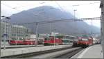 Ge 4/4 I der RhB, RBDe 560 NPZ, Re 4/4 II und 2x Re 460 aufgereiht im Bahnhof Chur, dahinter Brambresch, der Churer Hausberg erschlossen durch die neu gebaute Luftseilbahn.