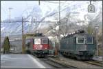 Re 4/4 II 11197 fhrt neben der abgestellten Re 6/6 11663  Eglisau  mit dem Rheintal Express in Landquart ein.