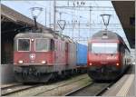 Der Lokfhrer des Gterzuges mit Re 4/4 II 11318 an der Spitze wartet auf die Freigabe der Strecke und Re 460 031-8 schiebt ihren IC DS aus dem Bahnhof Landquart Richtung Chur.